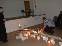 Kl. Valdemar Širvinski uždegtą žvakę padeda prie kryžiaus